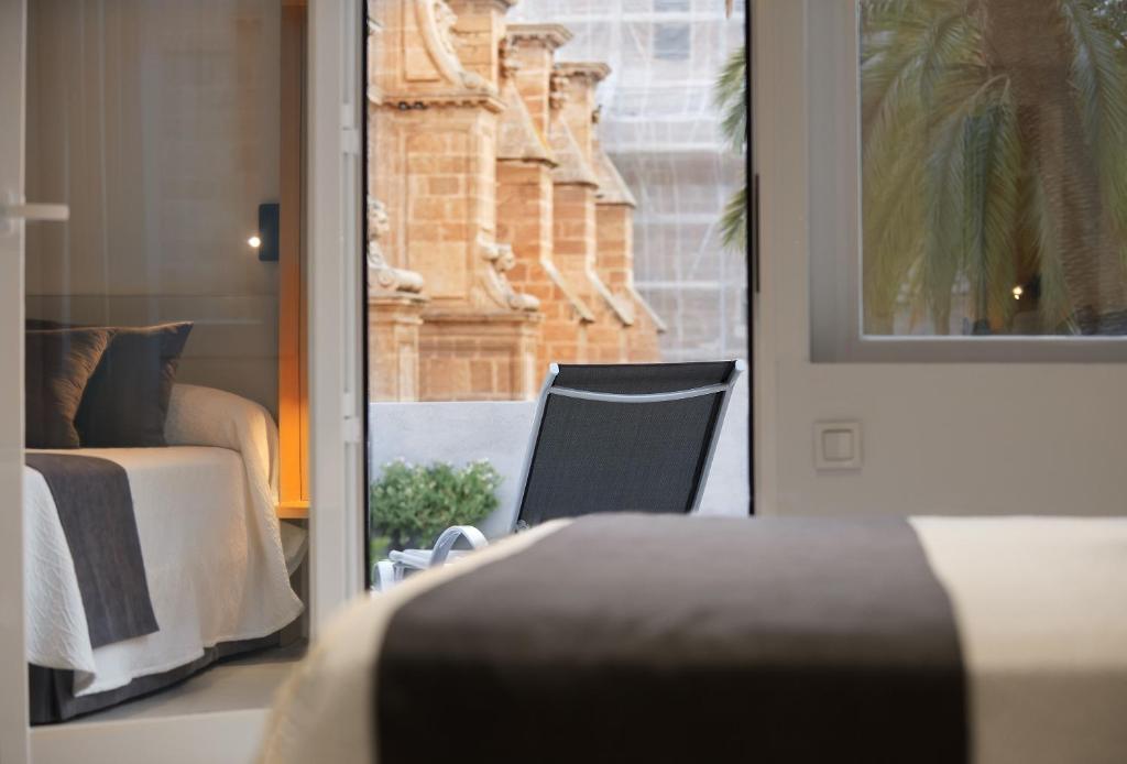 阿尔么丽亚阿尔梅里亚大教堂酒店的卧室配有床、椅子和窗户。