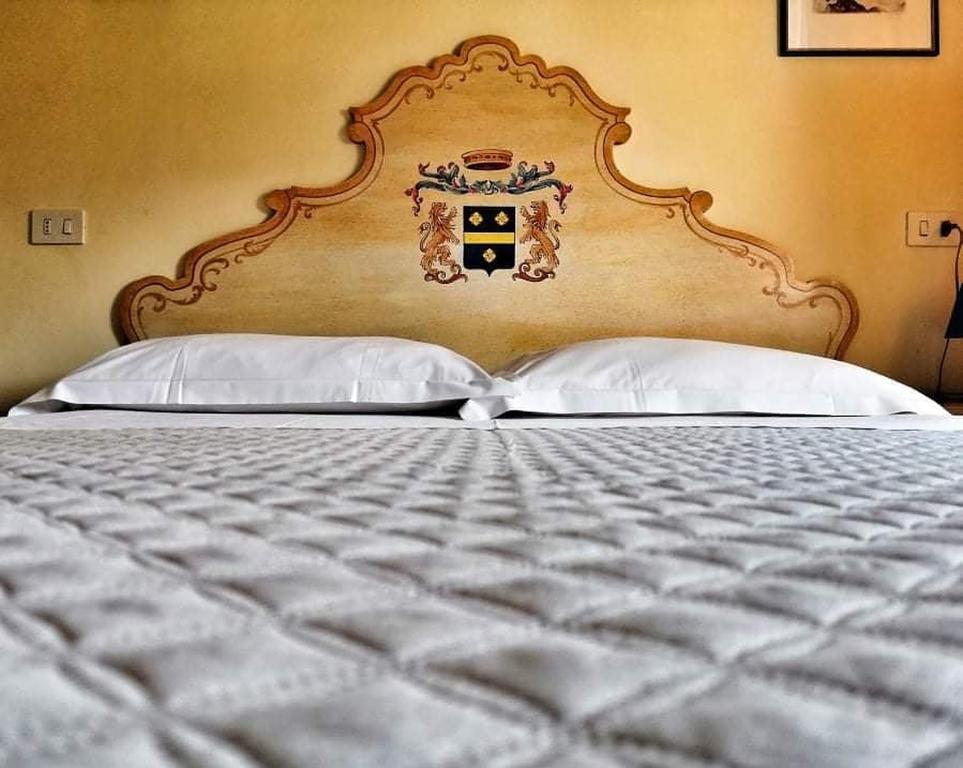 Bedonia圣安娜酒店的一张带大床头板和两个枕头的床
