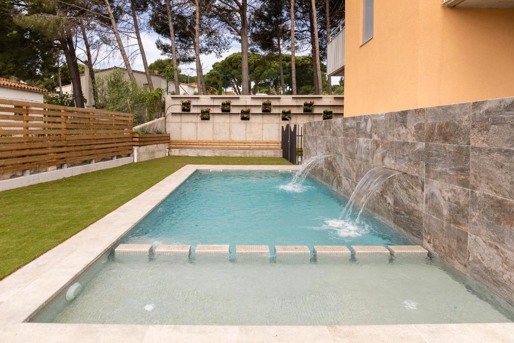 莱斯卡拉Albana Apartaments Turístics的庭院内带瀑布的游泳池