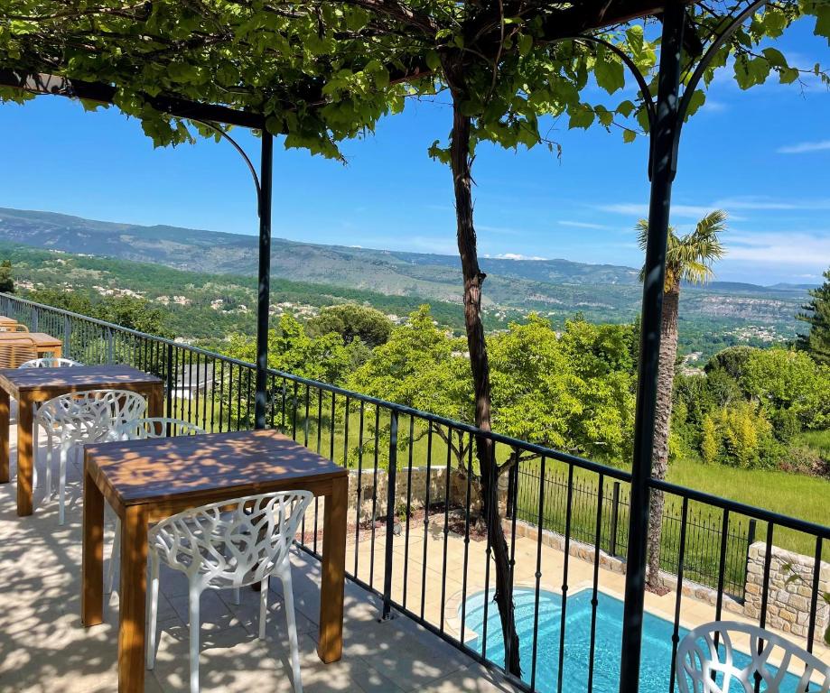 欧布纳Domaine de la Pinède的设有一个配有桌椅的阳台,享有美景。