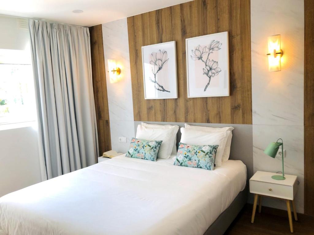 蓬德利马Hotel Rural Solar das Arcadas的卧室配有白色的床和2个枕头