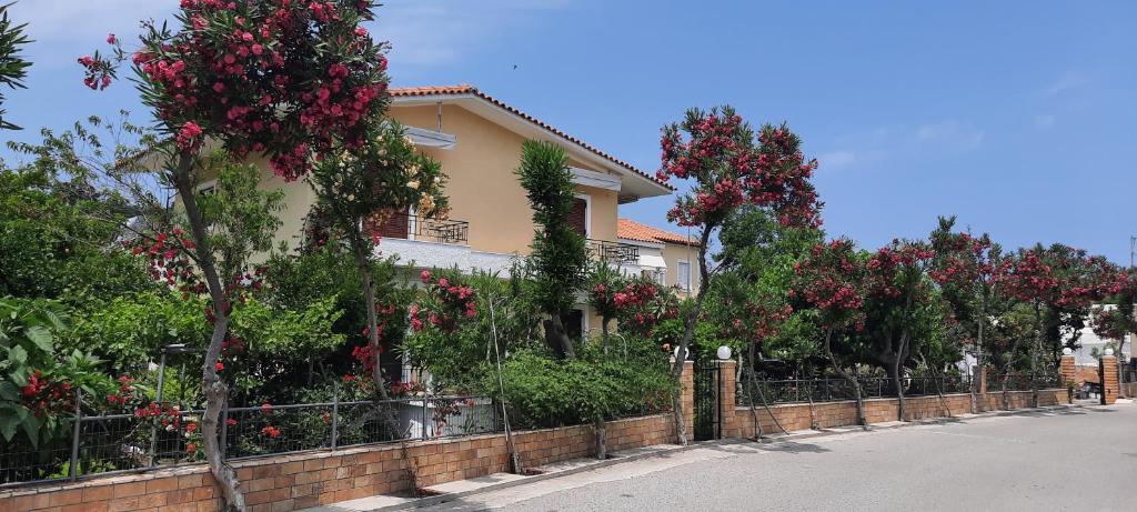 瓦西利卡koula's apartments的围栏前有红花树的房子