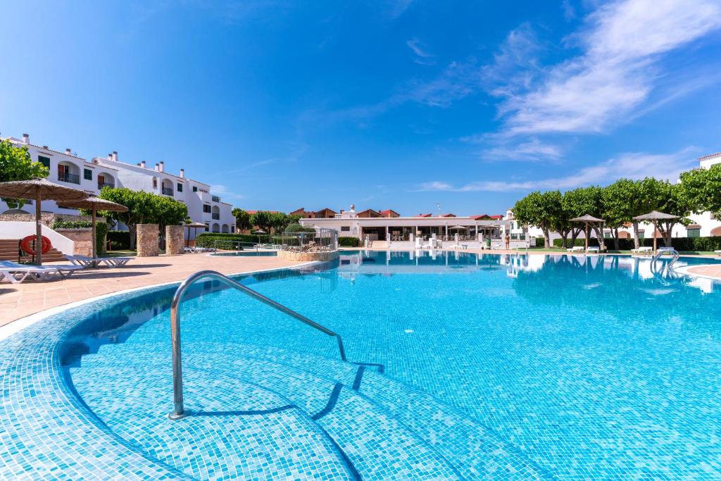 卡拉恩·布拉內斯维斯塔布拉内斯公寓式酒店的度假村的游泳池,配有椅子和遮阳伞