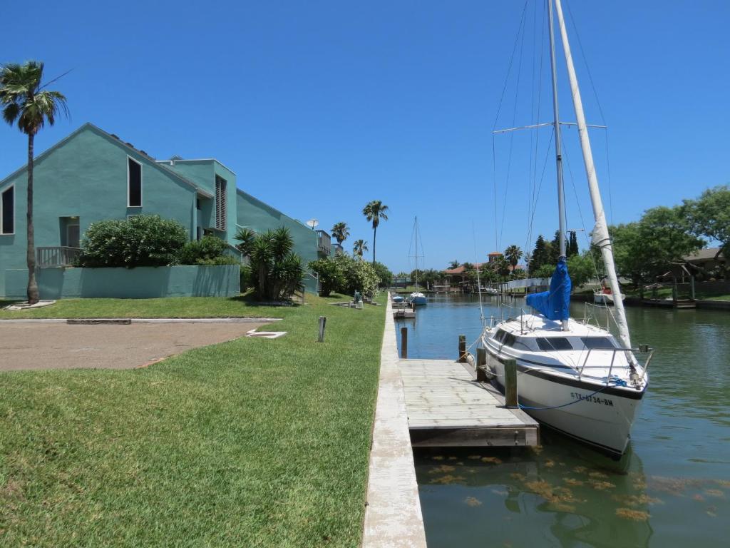 科珀斯克里斯蒂Multi Resorts at Puente Vista的停靠在房屋旁边的码头的帆船