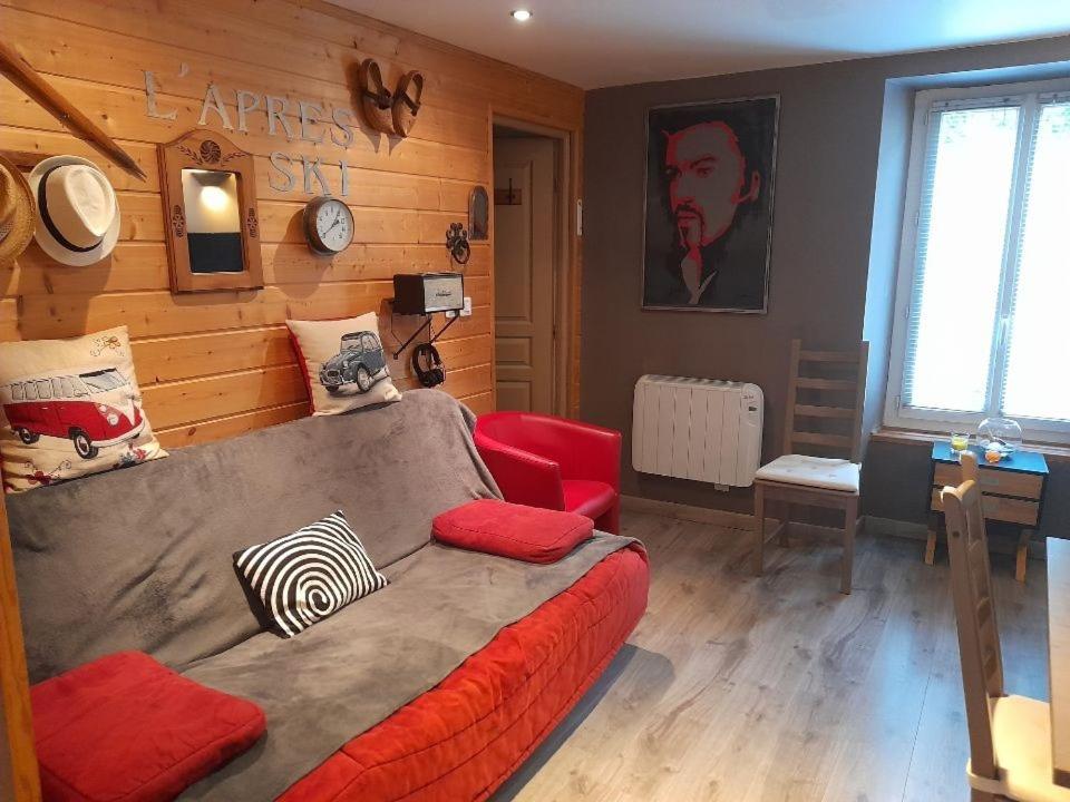阿克斯莱泰尔姆Le saquet的客厅配有床和红色沙发