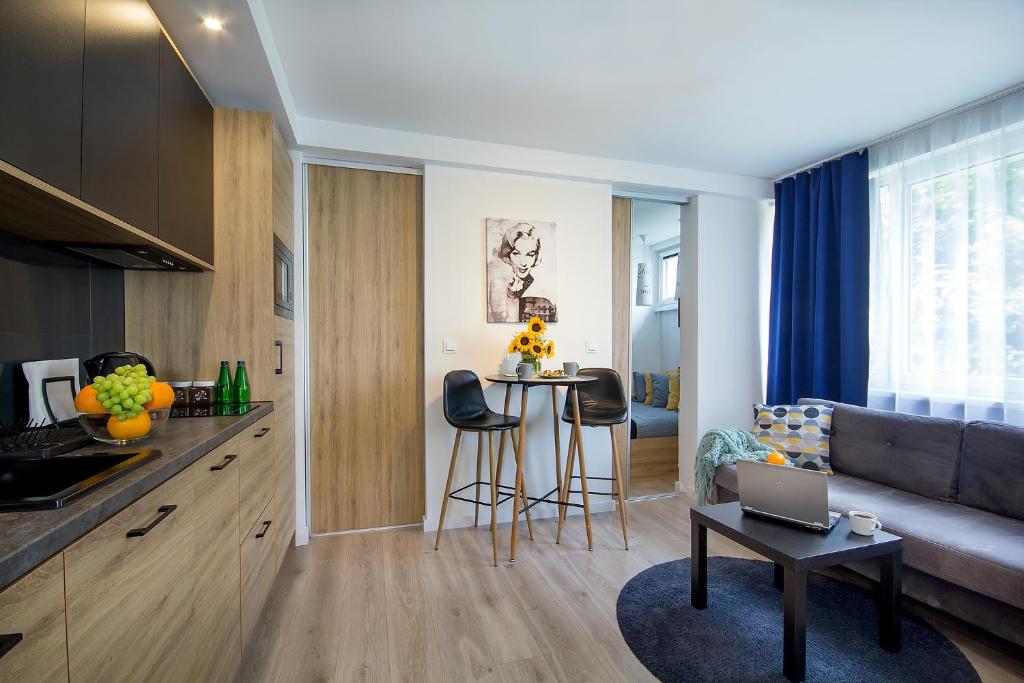 科沙林W&K Apartments - Compact I的厨房以及带沙发和桌子的客厅。