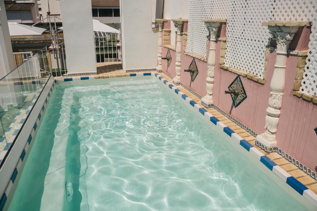塞维利亚Apartamentos Abreu Suites的游泳池,位于带游泳池的建筑内