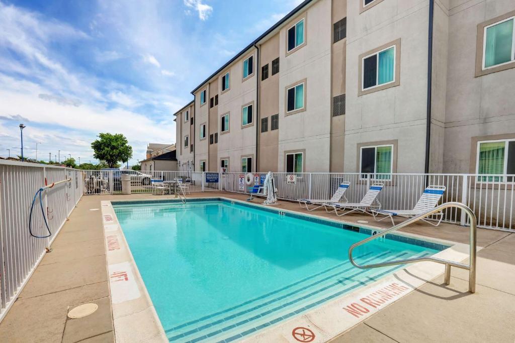 韦瑟福德Motel 6-Weatherford, TX的一座带椅子的游泳池以及一座建筑