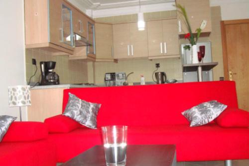 艾西拉Appartement de luxe的带桌子的厨房内的红色沙发