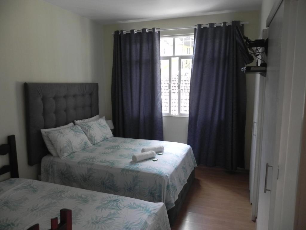彼得罗波利斯Aconchego Valparaíso的一间卧室设有两张床和窗户。