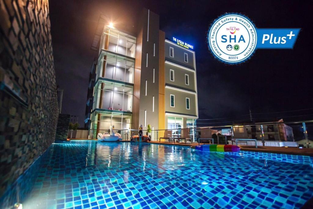 查龙The Elysium Residence - SHA Extra Plus的一座游泳池,在晚上在建筑物前