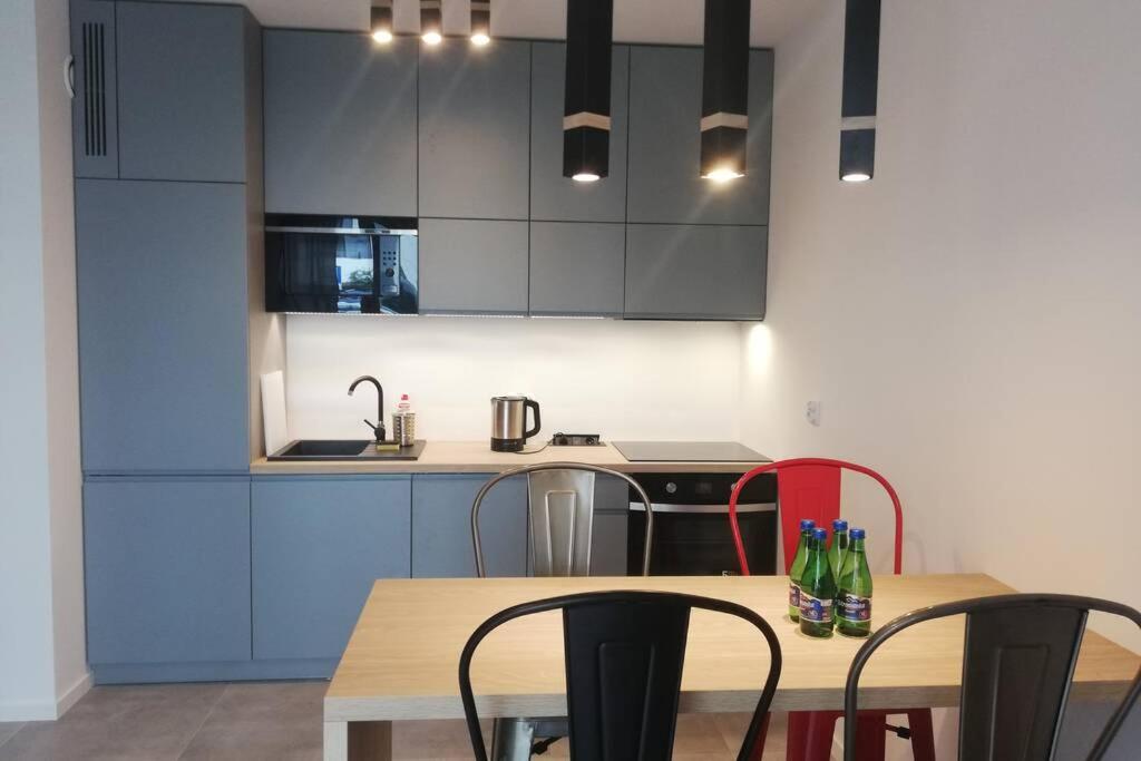 克拉科夫Apartament na Rydlówce的厨房配有蓝色橱柜和桌椅