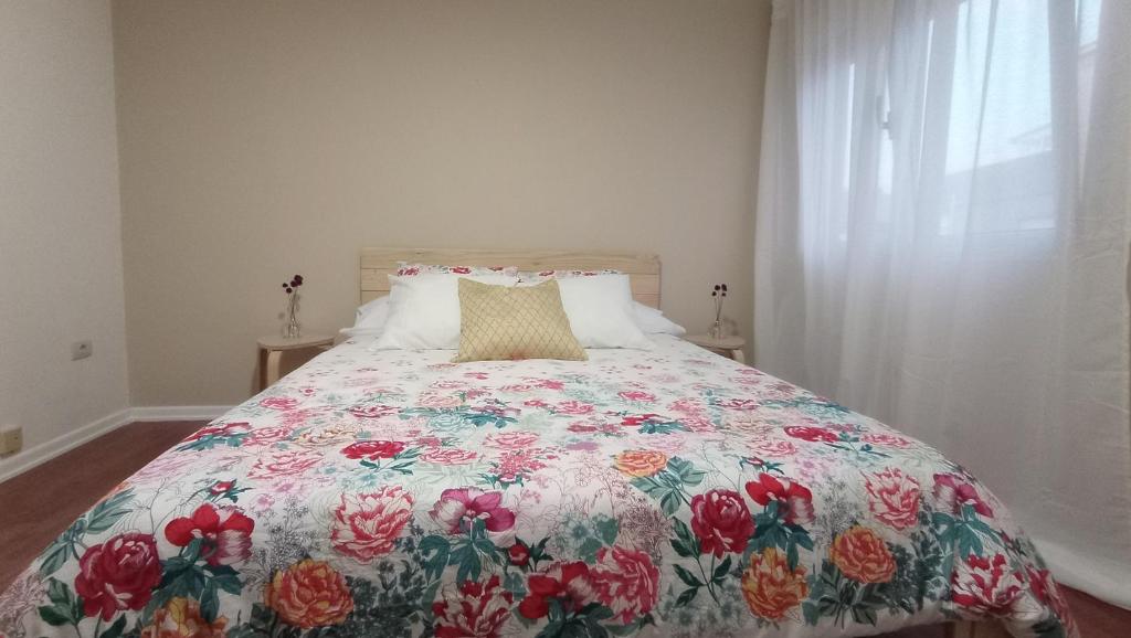 卡拉米尼亚尔镇O Lagar apartamento grande y luminoso. 8 personas.的一间卧室配有一张带花卉床罩的床