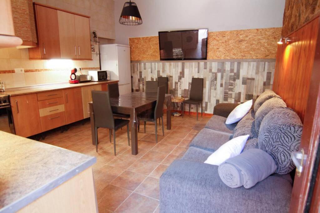 代尔特布雷Casa rural Antich Delta del Ebro的一间带蓝色沙发的客厅和一间厨房