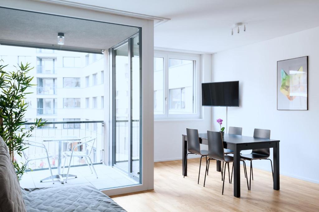 巴塞尔HITrental Basel Apartments的一间带桌椅的客厅和一间用餐室
