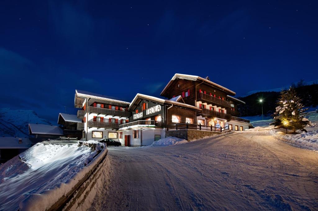 利维尼奥提欧拉酒店的一座大建筑物,在晚上下雪