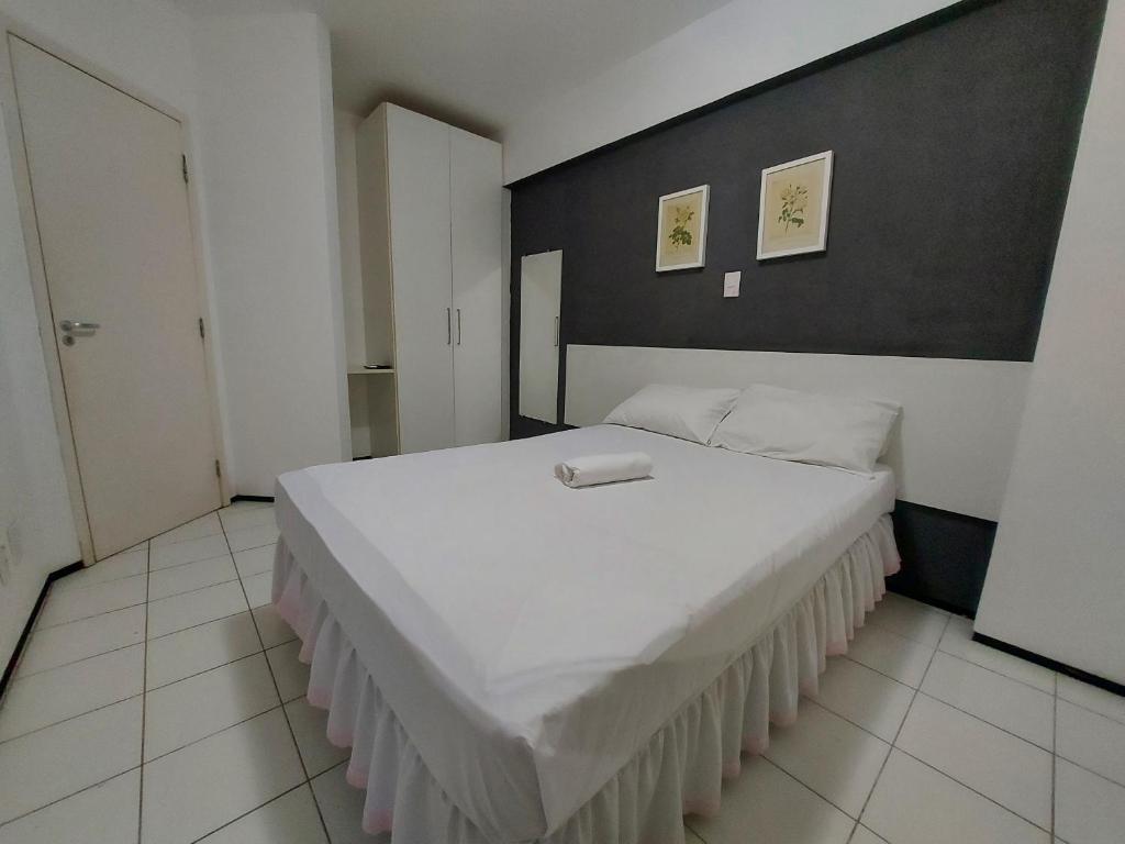 圣路易斯Flat Biarritz - Ao lado da Litoranea - Ferreira Hospedagens的一间卧室配有一张白色大床和黑色墙壁