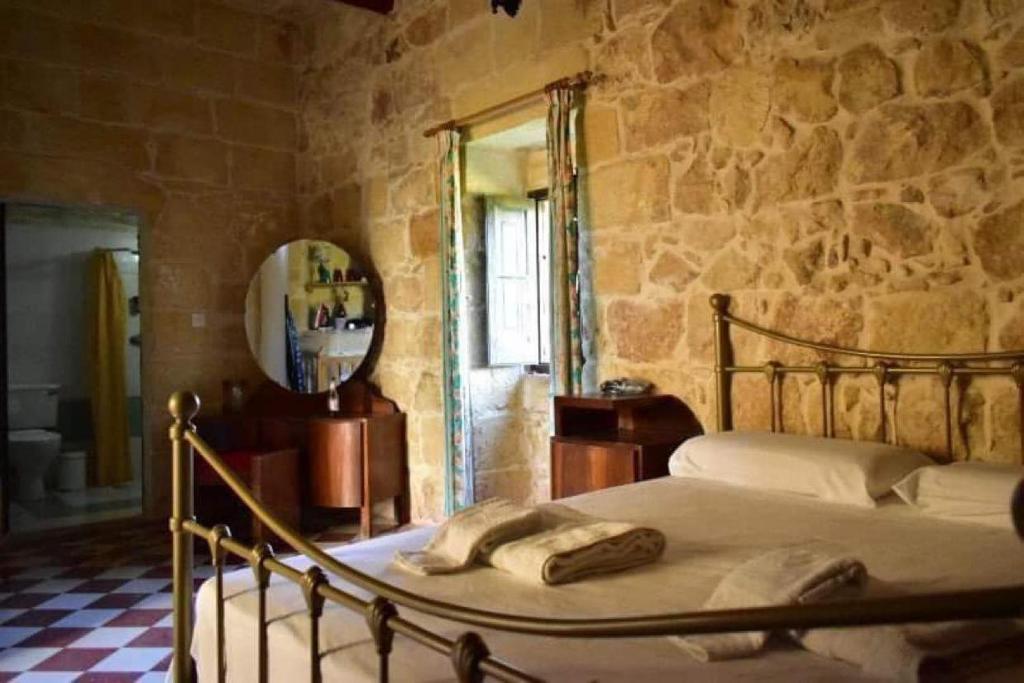 MunxarTa' Salvu u Marija的一间卧室设有一张床和石墙