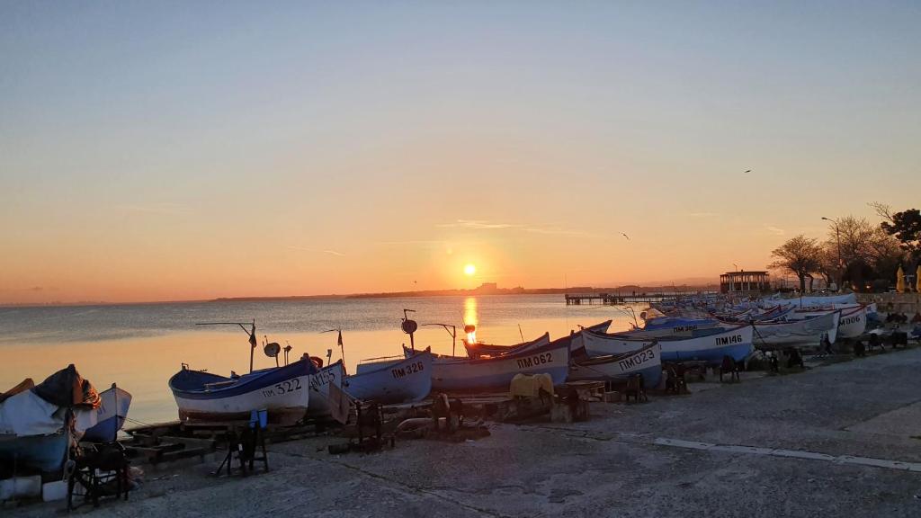 帕莫瑞Pomorie Beach Resort的日落时分停在海滩上的一组船