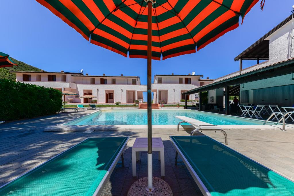 尼斯波特Elba Island Resort Pool & Tennis的游泳池旁的遮阳伞