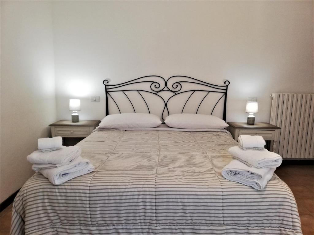 里奥马哲雷Amore Cove Apartment - Riomaggiore - 5 terre的一间卧室配有一张大床和毛巾
