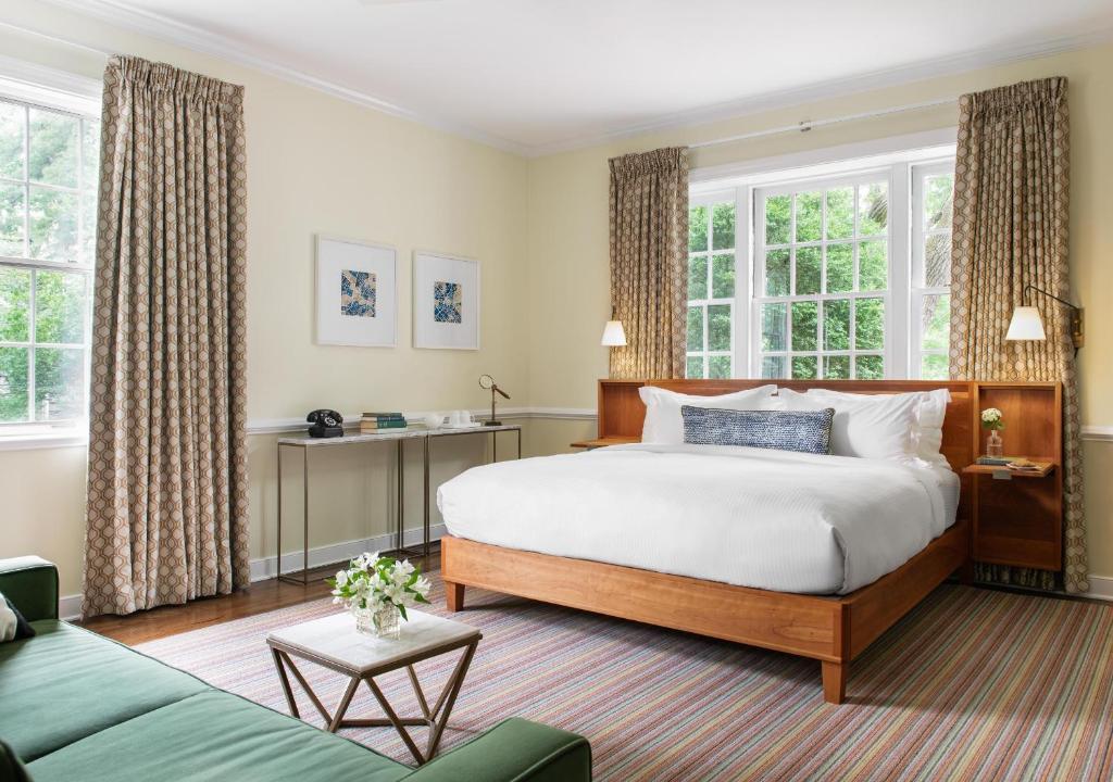 夏洛茨维尔奥克赫斯特酒店 的一间卧室设有一张大床和两个窗户。