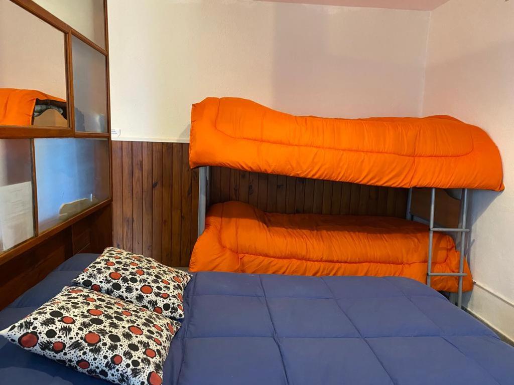 皮拉米德斯港El Canto de la Ballena Loft的一间卧室配有两张双层床和橙色床单。