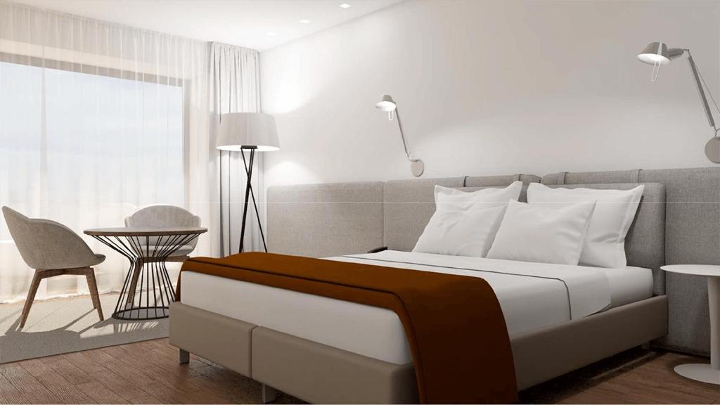 维亚纳堡夫劳德萨尔酒店的卧室配有1张床、1张桌子和1把椅子