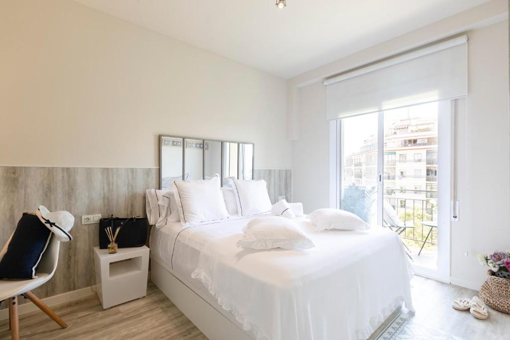 巴塞罗那Chic Gran Via Apartment的白色的卧室设有一张大床和一个窗户