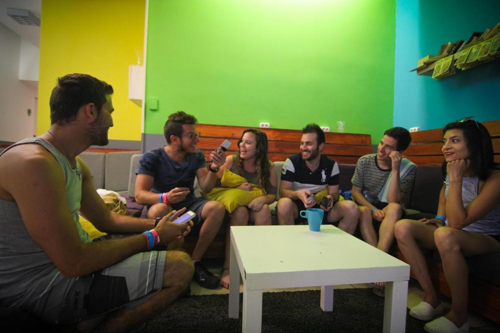 布达佩斯Onefam Budapest的一群坐在长凳上玩电子游戏的人