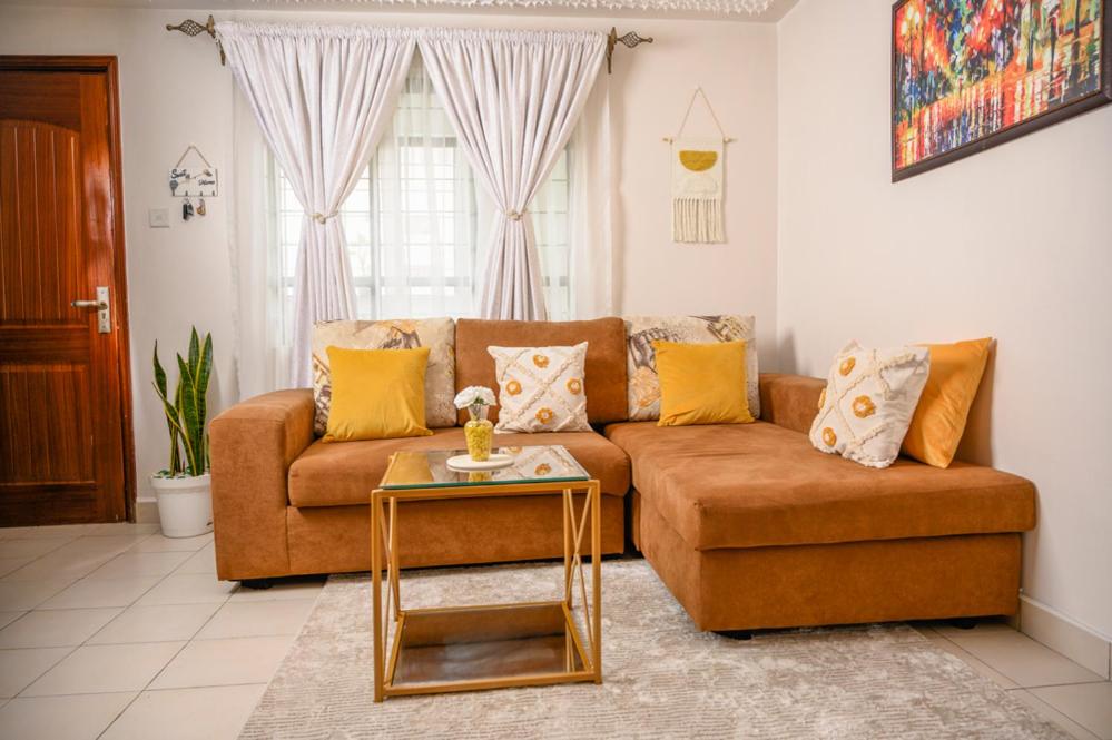 内罗毕Furnished 1 Bedroom Apartment in Nairobi. 15 Mins to CBD. Free WI-FI & Parking的客厅配有沙发和桌子