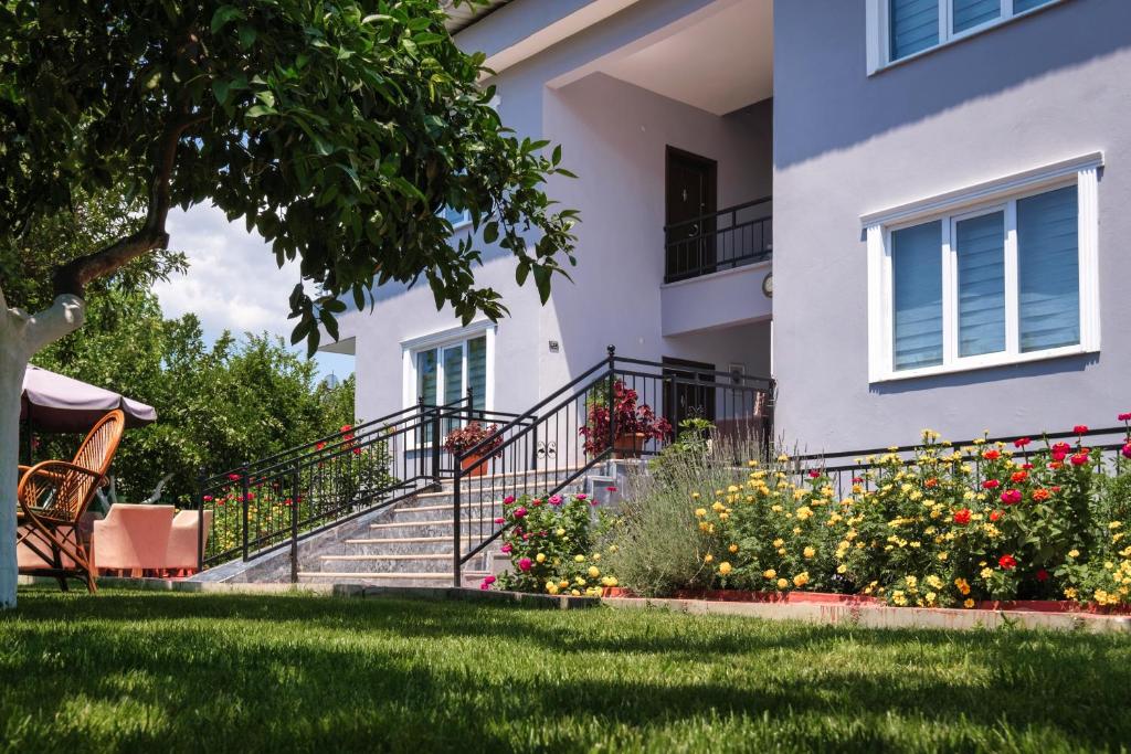 凯麦尔KAĞAN Holiday Apartments的庭院里一座带楼梯和鲜花的房子