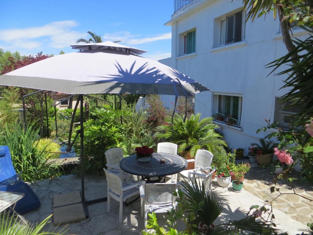 圣特罗佩英格丽别墅旅馆的一个带桌子和遮阳伞的庭院