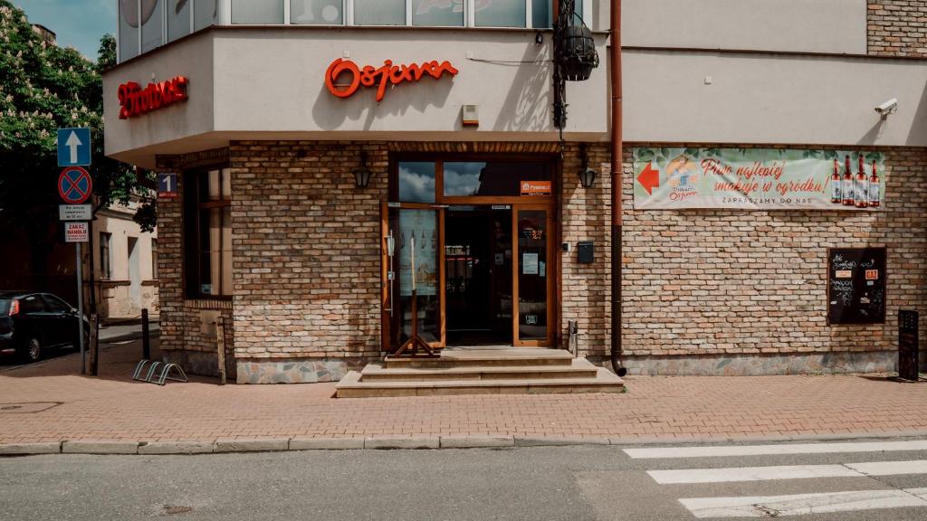 比亚瓦波德拉斯卡Browar Osjann - pokoje gościnne的砖楼前的商店,门打开