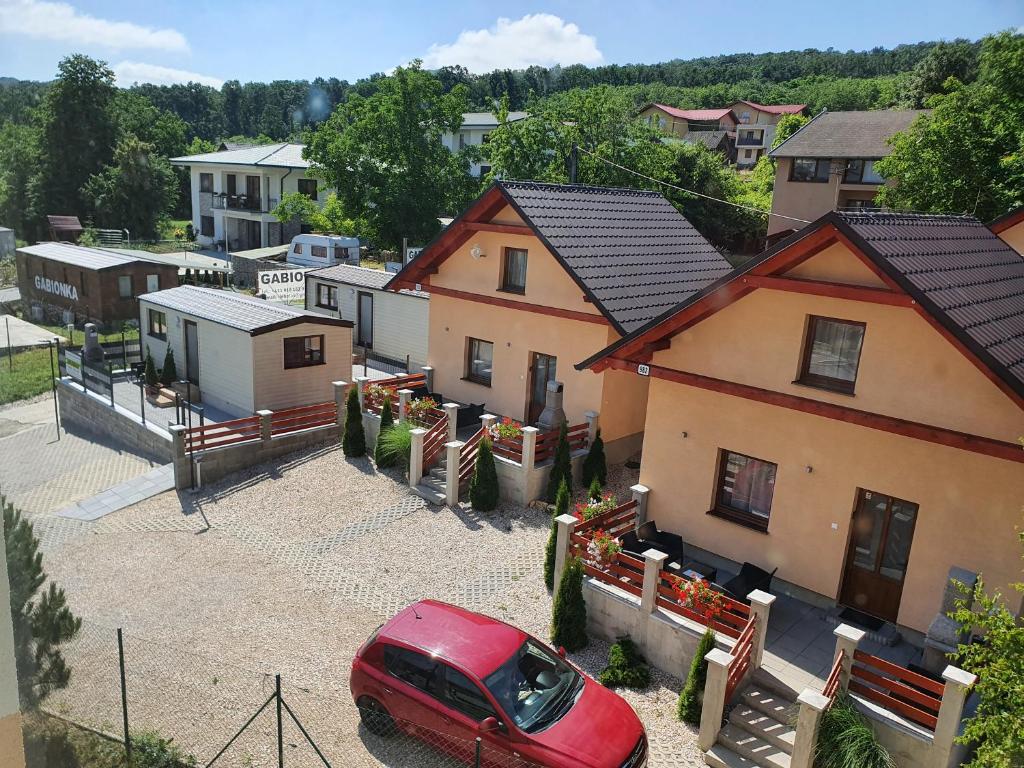波达雅斯卡Bungalows Michalka - Podhájska的停在房子旁边的停车场的红色汽车