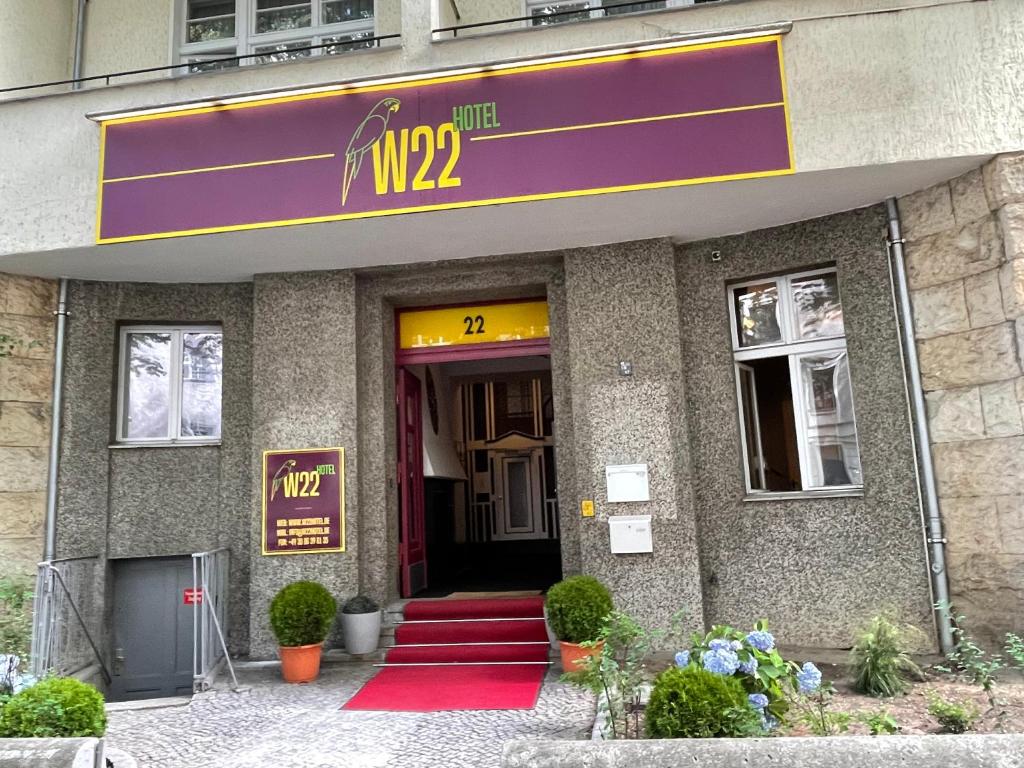 柏林W22 Hotel am Kurfürstendamm的前面有紫色标志的建筑