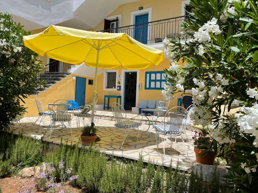 卡西奥皮向日葵公寓式酒店的庭院配有黄色遮阳伞和桌椅