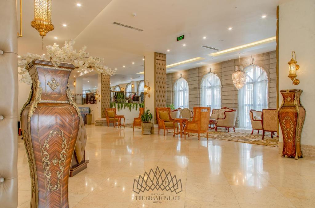 亚的斯亚贝巴The Grand Palace Hotel的大堂设有两瓶花瓶和椅子