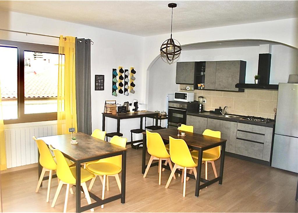 奥尔比亚Verba Mundi Guest House的厨房以及带黄色椅子和桌子的用餐室。