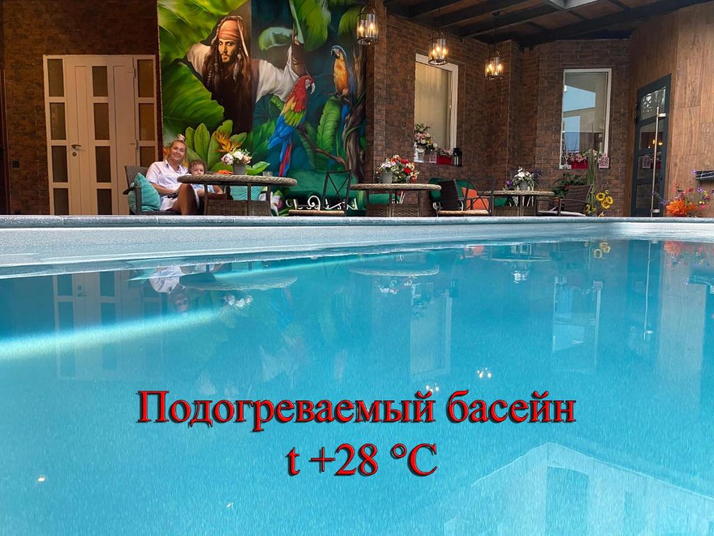 阿德勒尼卡酒店的一座大型游泳池,旁边是一幅画,旁边是女人
