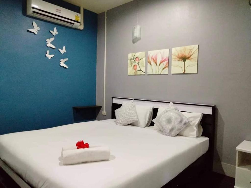 奥南海滩甲米府尼奥旅馆的卧室配有白色的床,墙上有鸟儿