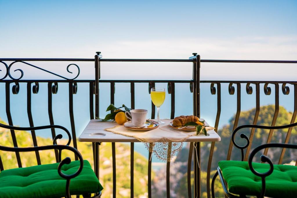 斯卡拉CASA BELLAVISTA Scala Minuta Amalfi Coast的一张桌子,上面放着一杯橙汁和一盘食物