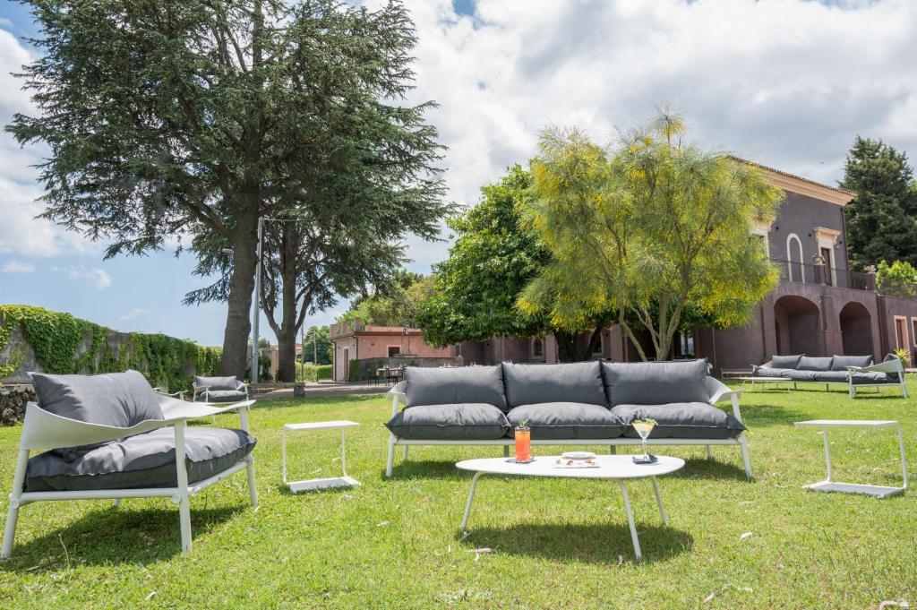 卡迪里翁西塞尔Santoro Country House的一个带两张沙发和一张桌子的庭院