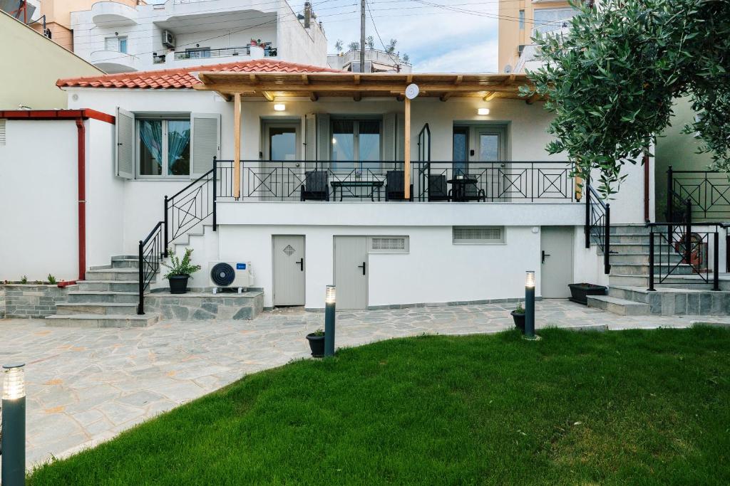 卡瓦拉Ilios house的白色的大房子,设有门廊和楼梯