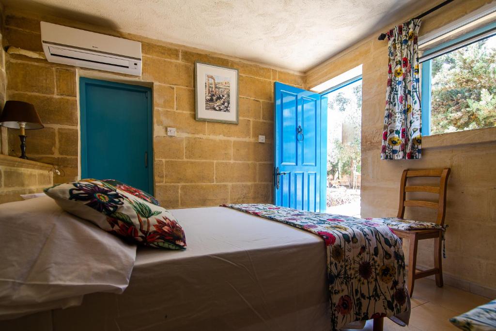 Ħal Far塔博图寄宿简易旅馆的一间卧室配有一张床和一个蓝色的门