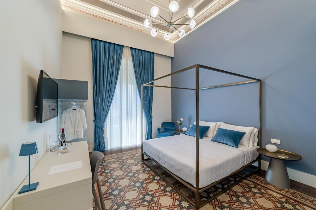 卡塔尼亚Ciuri di Strata的一间卧室设有天蓬床和蓝色的墙壁。