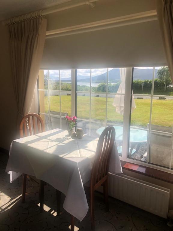 Achill Sound穆拉维尔住宿加早餐旅馆的一张桌子、两把椅子和大窗户