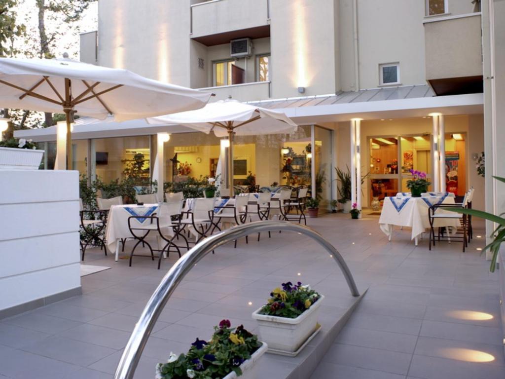 里乔内尼维斯酒店的一个带桌椅和遮阳伞的户外庭院。