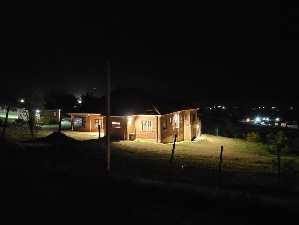 LusikisikiKwaNomzi Botique Lodge的夜晚有灯的小屋