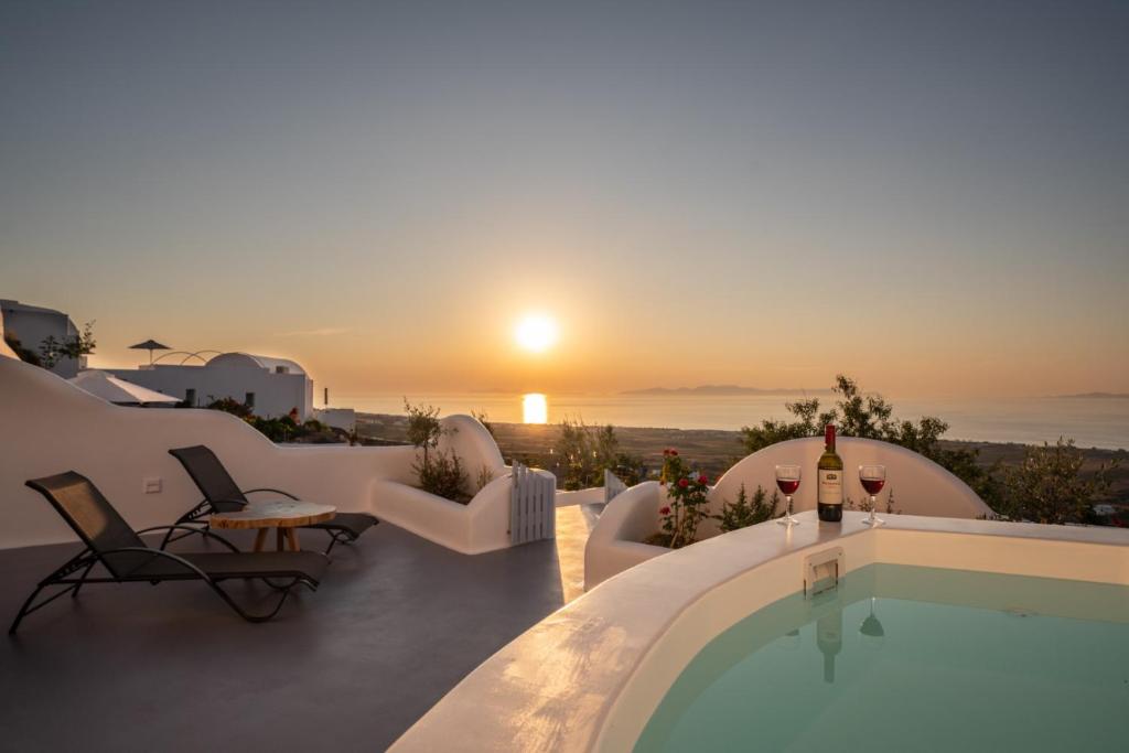伊亚Sun Angelos Oia - Luxury Cave Suites的一座别墅,设有游泳池和日落美景